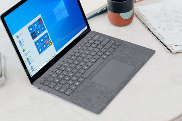 gray microsoft surface laptop computer on white table