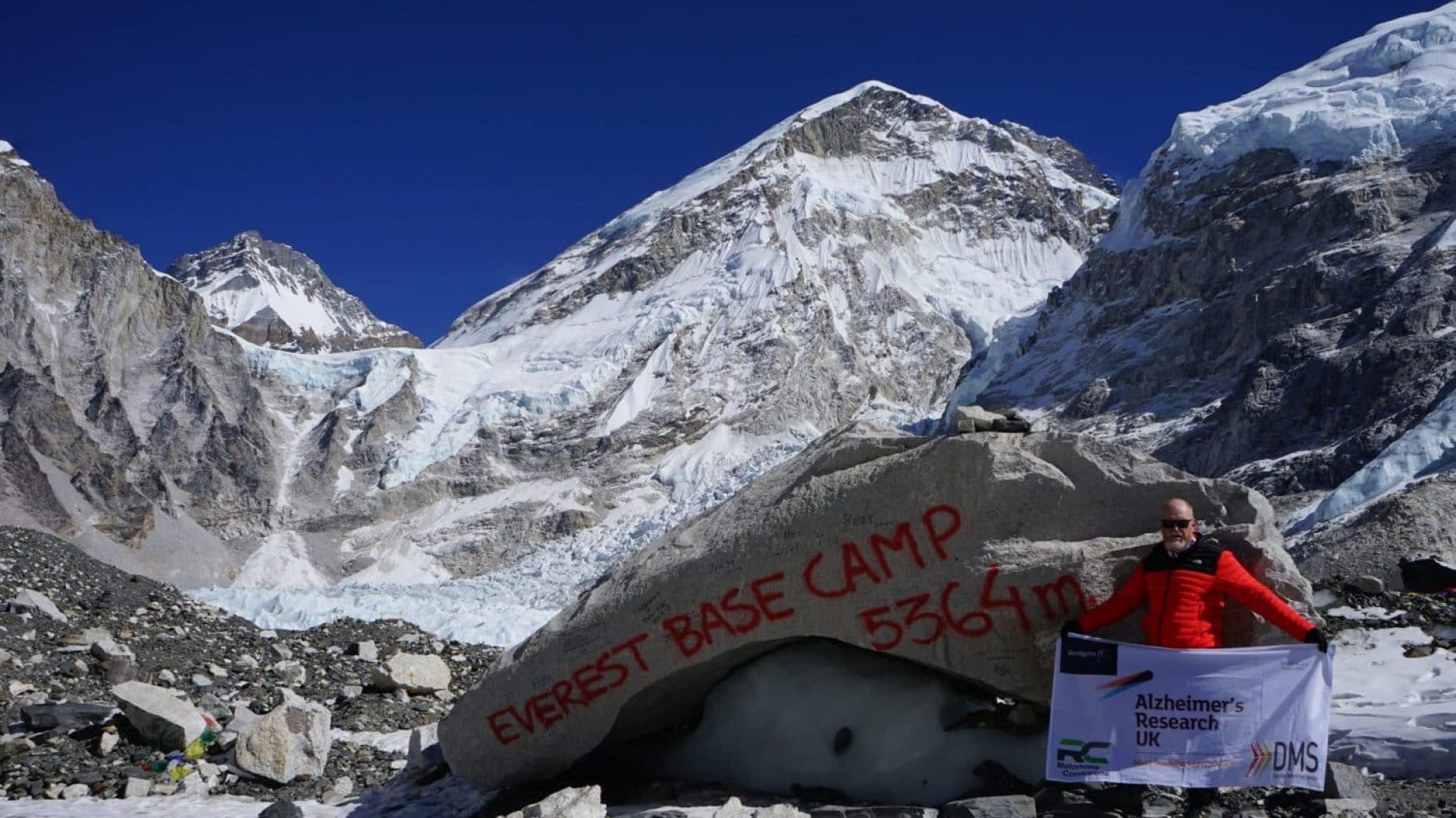 Mitchell Smith displays the flag at Everest Base Camp